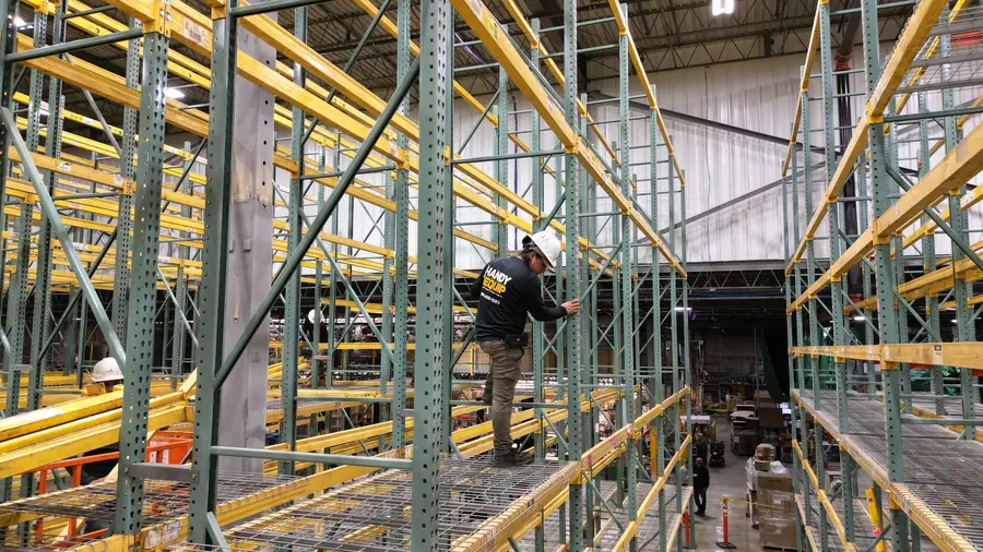 Worker installing pallet rack beams